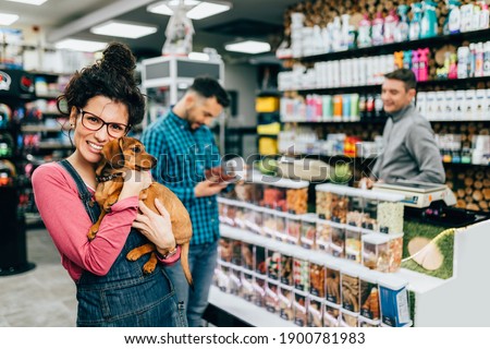 Customers buying accessories and food for their pet in pet shop.