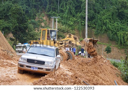 NORTHERN LAOS - AUGUST 14: Bulldozer clears the road because of landslide on August 14, 2012 in Northern Laos. Landslides are common in Laos because annual rainfall is up tu 4 m per year,