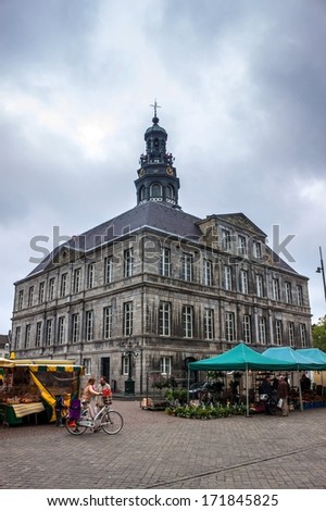 MAASTRICHT, JUN 1: Unidentified people walk on a Market Square in front of a town hall in Maastricht, Netherlands on Jun 1, 2013. Town hall was built in the 17th century by Pieter Post.