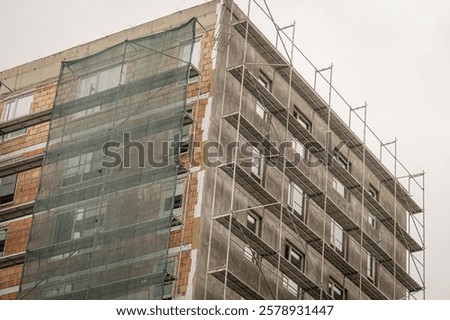 Similar – Image, Stock Photo Scaffolding with protective net and tarpaulin from frog perspective / house renovation