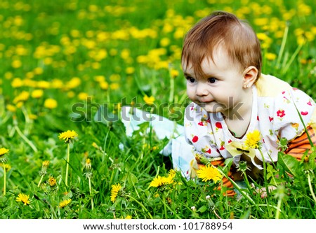 Cute little baby on the dandelion meadow