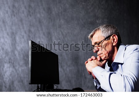 Worried elderly businessman using computer