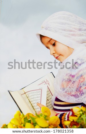 Muslim girl holding Holy Book Koran