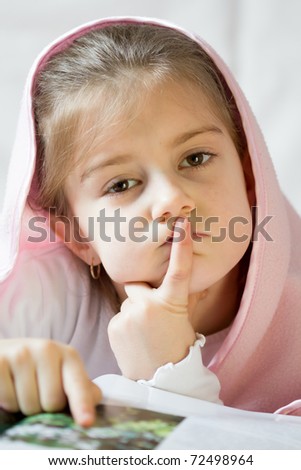 girl reading under blanket