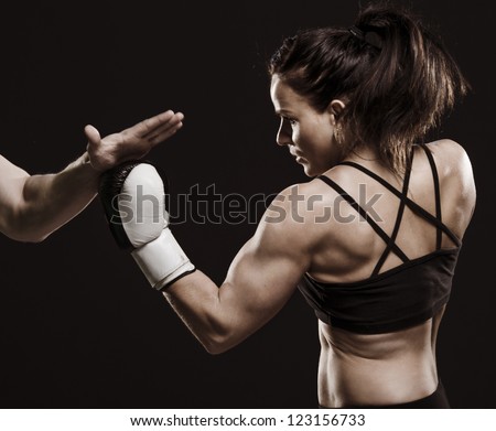 A studio shot of beautiful fitness woman training boxing.