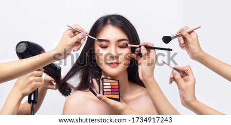 Beautiful Asian woman with many hand professional beautician makeup artists. Asian girl makeup by makeup artist team. Beauty of women.