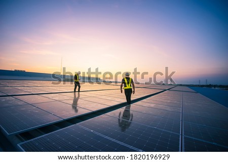 Technology solar cell, Engineer service check installation solar cell on the roof of factory on the morning. Silhouette technician inspection and repair solar cell on the roof of factory. Foto stock © 