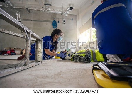 First aid builder accident in site work. Team paramedic first aid for head injuries. Employee accident in construction site work. Emergency service. First aid procedure.
