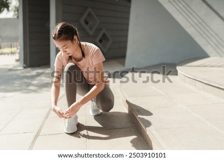 Image, Stock Photo Sporty woman tying laces on sneakers before training