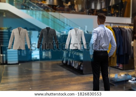 iot smart retail futuristic technology concept, happy man try to use smart display with virtual or augmented reality  in the shop or retail to choose select ,buy cloths and give a rating of products 