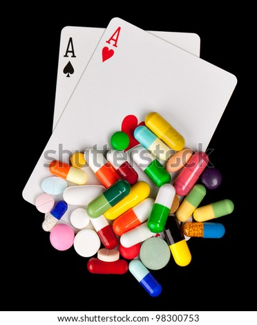 A pile of colorful pills over a pair of aces.