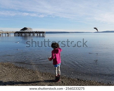 Foto Bild Mädchen füttert Möwe an der Küste