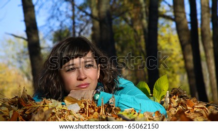 Young girl lying in the autumn fall leaves