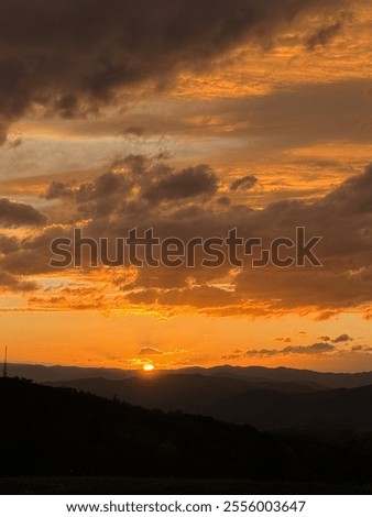 Similar – Foto Bild Die Sonne verschwindet hinter den Bäumen. Hinter dem Haus ist es schon dunkel. Eine starke Bewölkung gibt dem ganzen ein prächtiges Panorama.