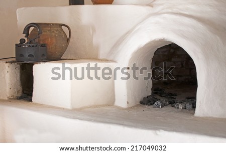 White rustic brick oven with pot and iron