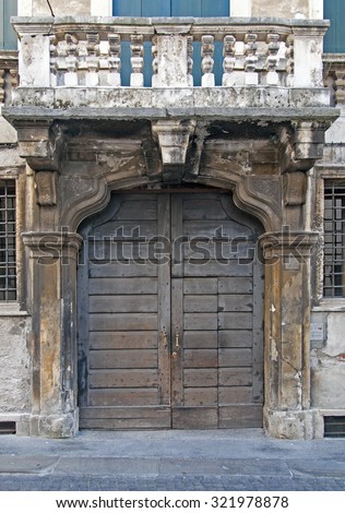 Decayed wooden door on ruined stone facade