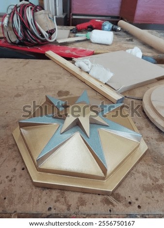 A star-shaped wooden Christmas tree pendant with a gold glittering edge