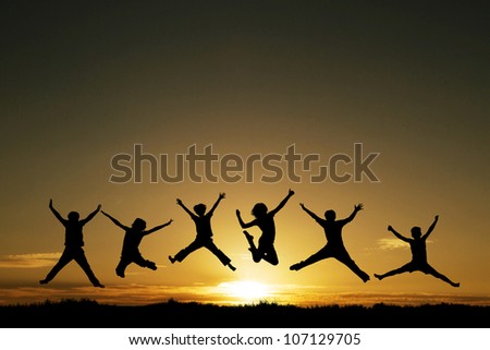 silhouette of teenagers jumping in sunset for fun