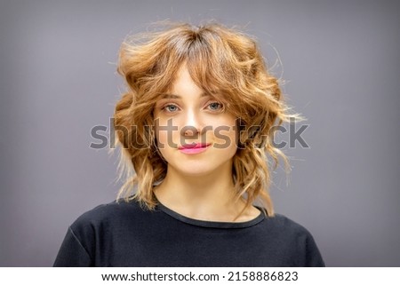 Similar – Image, Stock Photo Young dark haired woman with curls and freckles looks half behind white steam cloud into camera in blue green light