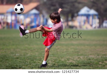 Boy kicking soccer in the park - Authentic action with soccer ball - copy space - landscape format