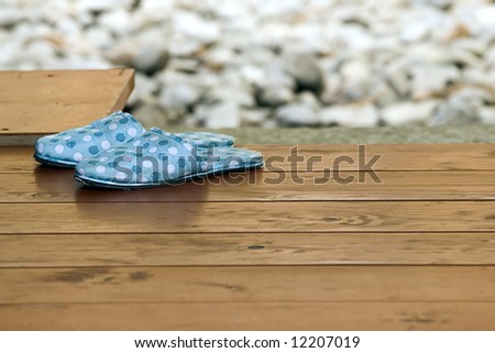A view of slippers or low-heel shoes left on an outside deck before entering a house, Japanese style.