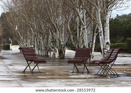 Three street chairs wet in a rainy day in Barcelona Spain
