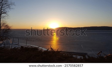 Similar – Image, Stock Photo Sunset over a frozen lake. Sunbeams falling on water. Shadows of trees on the ice covering the lake. Aerial view of a frozen lake. Ice sheet background. Frozen grass in water