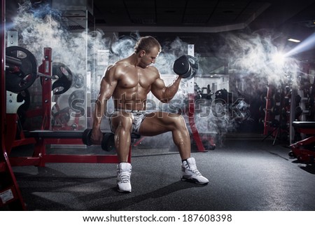 very power athletic guy , execute exercise press with dumbbells, workout in the gym