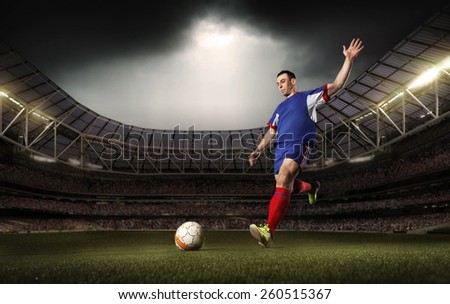 A soccer player kick the ball on tha stadium