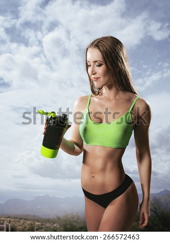 Fitness woman drinking water after running at outdoor Thirsty sport runner resting taking a break with water bottle drink outside after training. Beautiful fit sporty caucasian girl.