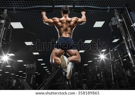 Athlete muscular fitness male model pulling up on horizontal bar in a gym 商業照片 © 
