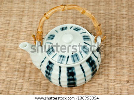 porcelain teapot with bamboo handles on the mat