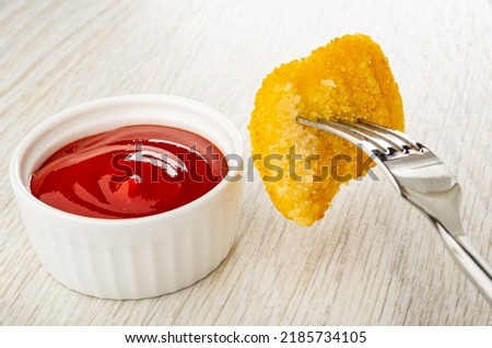 White bowl with ketchup, fried chicken nuggets strung on fork on wooden table Imagine de stoc © 