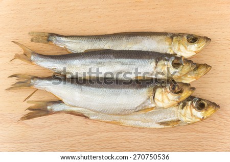 Some smoked fish on board of beech