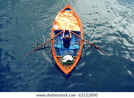 Young man on a boat : rowing fisherman