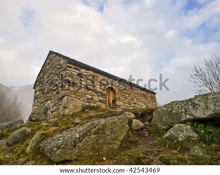 XIII Century Romanesque church, with several stones in the foreground. Horizontal composition