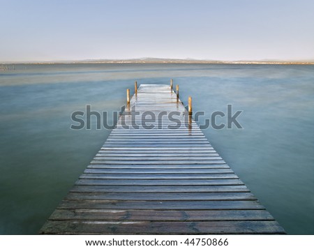 Wooden jetty in a lake. Long time exposure used to create a silk effect on the water surface