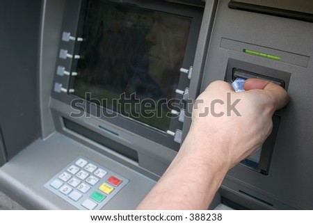 Man using teller machine - Inserts a card