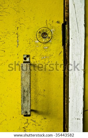 Door handle and keyhole on the rusty yellow plate
