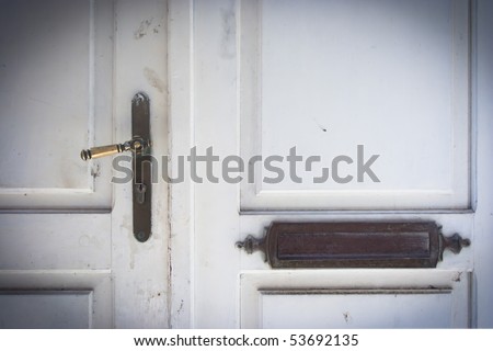 Old white doors with handle and name plate.