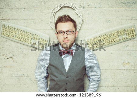 Concept photo of young fashion computer man like an angel with bowtie, suit, eyeglasses and keyboards instead wings