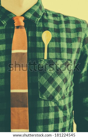 Oldtimed man with tie and a yellow spoon in the pocket