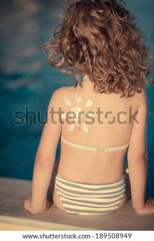 Sunscreen lotion sun drawing on children back. Summer vacation concept
