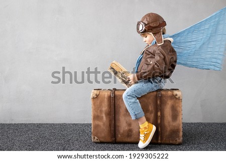 Happy child playing outdoor. Smiling kid dreaming about summer vacation and travel. Imagination and freedom concept