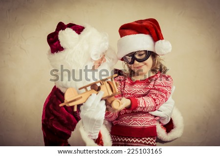 Santa Claus and child playing with vintage wooden plane at home. Christmas gift. Family holiday concept