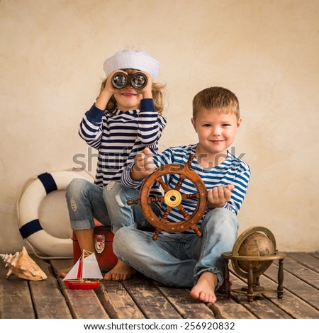 Children playing with vintage nautical things. Kids having fun at home. Travel and adventure concept. Retro toned image