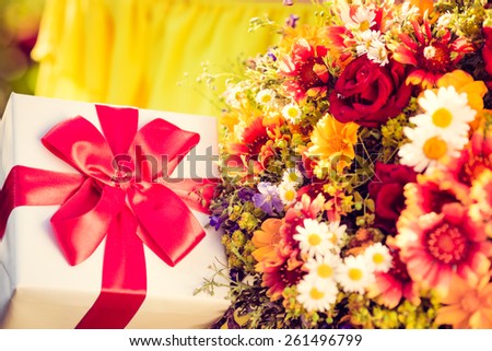 Gift box and flowers against spring background. Family holiday concept. Mothers day