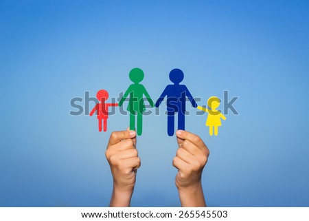 Paper family in hands against summer sky background
