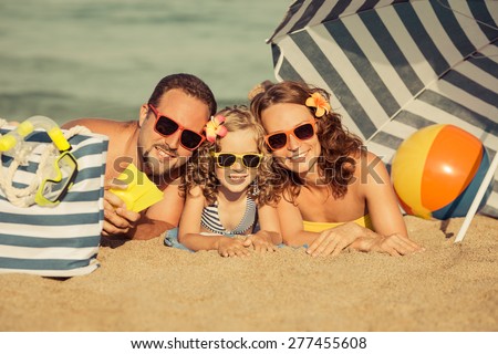 Happy family lying on the beach. Summer vacation concept. Retro toned image