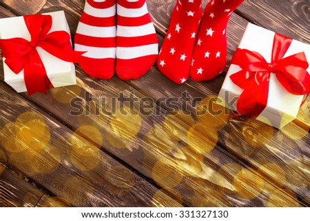 Feet wearing Christmas socks on wood floor. Happy family at home. Xmas holidays concept